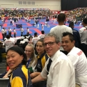 Senseis Robyn & Sean, Alannah, and Riana watch Belinda compete in Junior Female Kumite (with an Indonesian photo bomber)